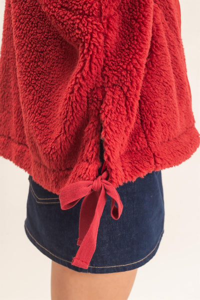 close up of side ties on red sherpa vest