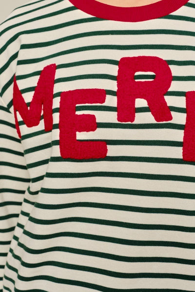 Close-up of a striped knit top with horizontal green and off-white stripes, featuring large red letters spelling part of a word across the chest.