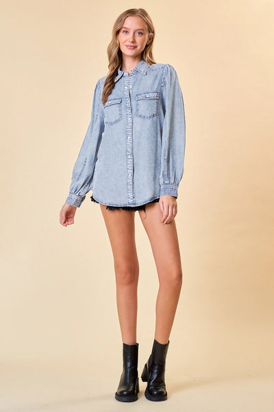 model wearing a long sleeve denim top & cutoff shorts on tan background