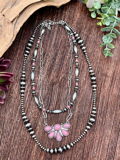 Necklace with pink pendant on a wooden surface