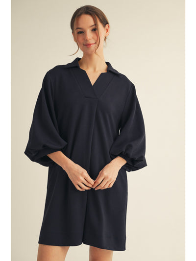 Woman wearing a black dress with a plain background