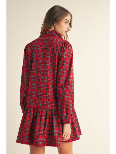 Red plaid dress worn by a model on a beige background