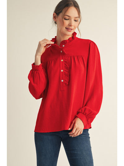 Woman wearing a red blouse with long sleeves on a beige background