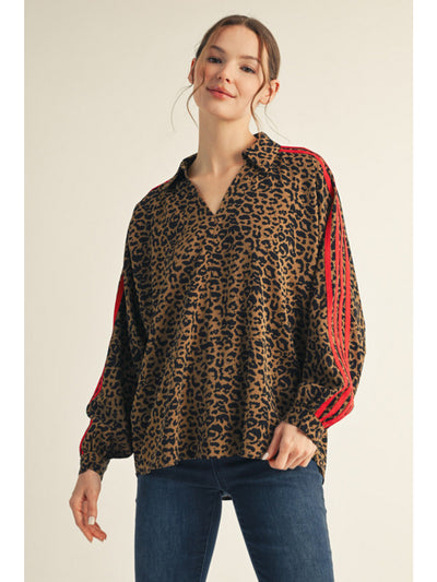 Woman wearing a leopard print top with red accents on a beige background