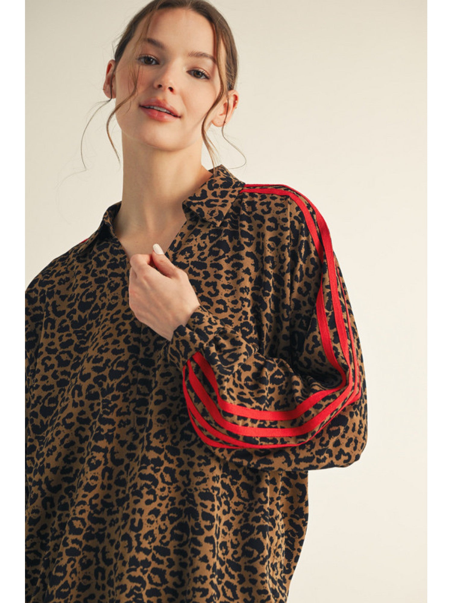 Woman wearing a leopard print jacket with red stripes on a beige background