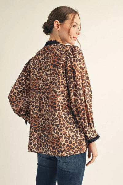Woman wearing a leopard print blouse with a plain background