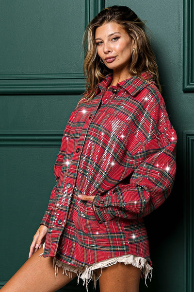 Woman wearing a red plaid shirt with sequins against a green wall