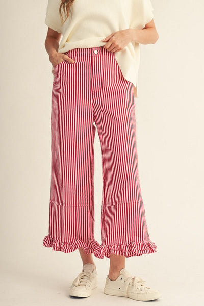 Person wearing red and white striped pants on a beige background