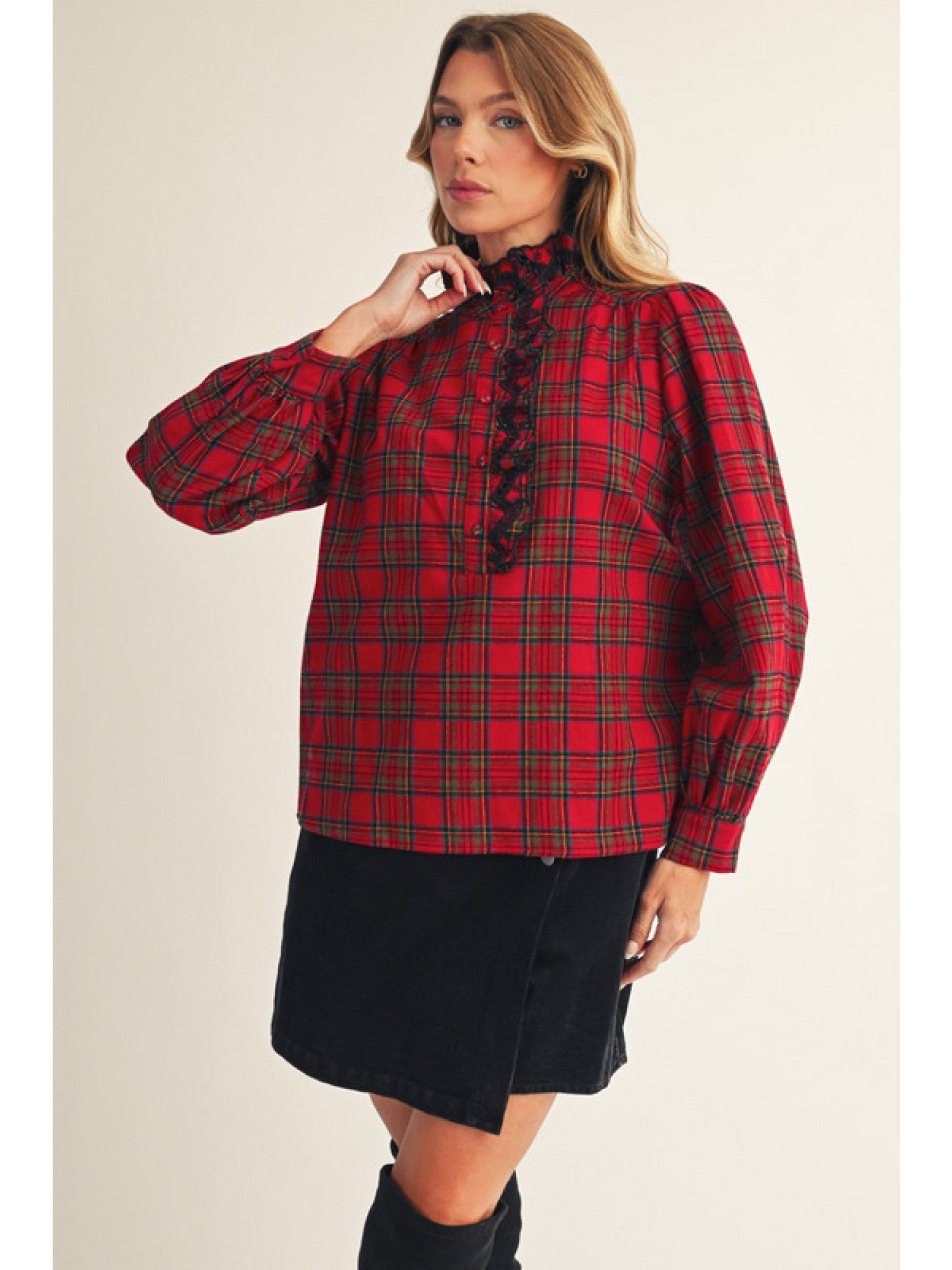 Woman wearing a red plaid blouse with a plain background