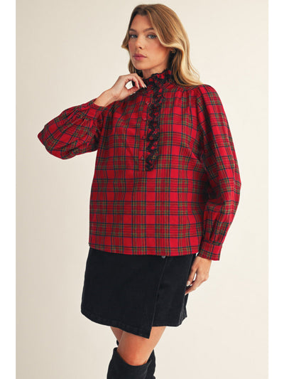 Woman wearing a red plaid blouse with a plain background