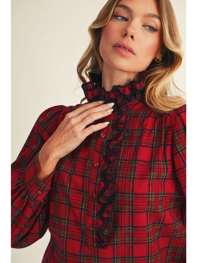 Woman wearing a red plaid blouse with a high collar.