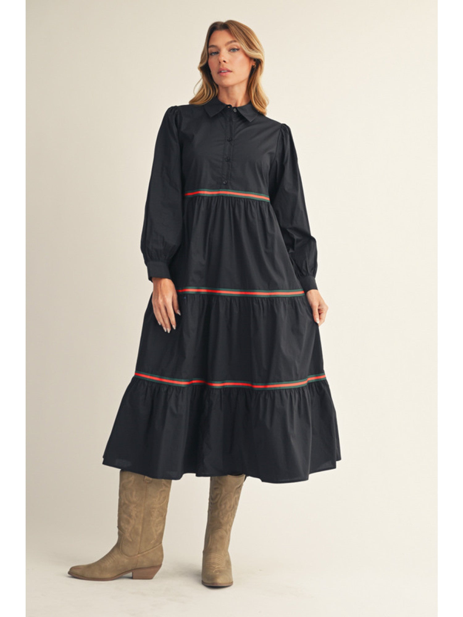 Woman wearing a black dress with red accents on a beige background