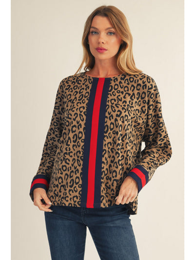 Woman wearing a leopard print sweater with red and navy stripes on a plain background