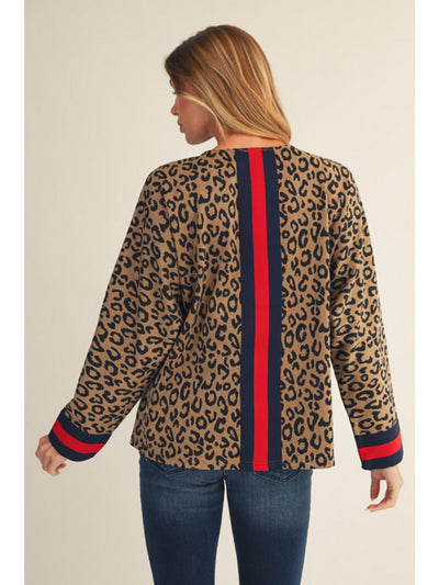 Woman wearing a leopard print jacket with red and blue accents on a beige background