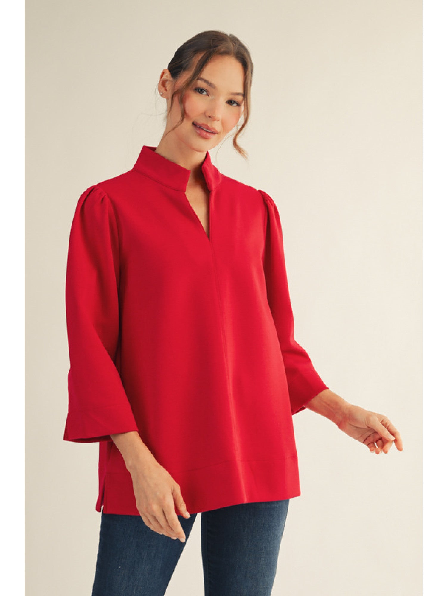 Woman wearing a red blouse with a plain background