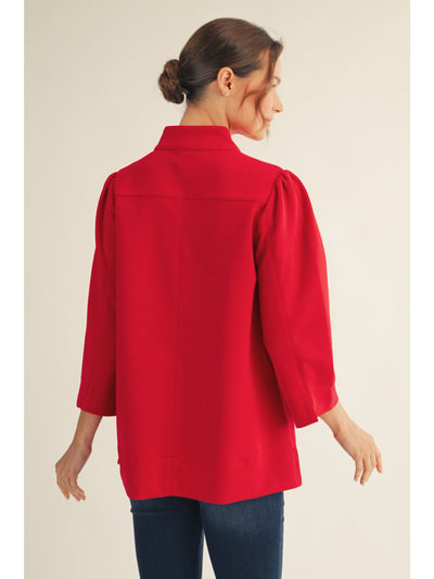 Woman wearing a red blouse with a neutral background