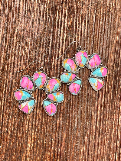 Pink Mix Naja earrings on a wooden surface