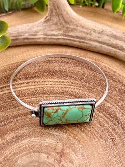 green rectangle bracelet on wooden background