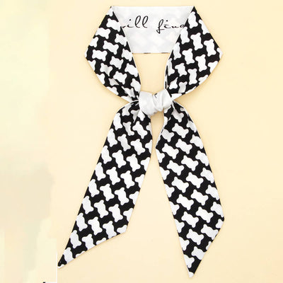 Black and white patterned scarf with a bow on a beige background