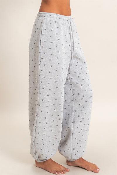 side view of model wearing gray joggers with star print