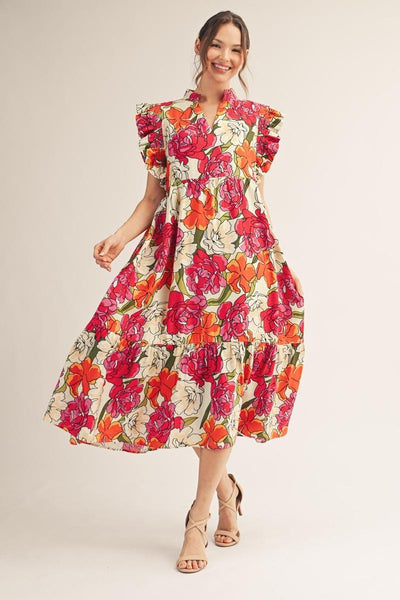model wearing a a pink & orange floral dress with a light background
