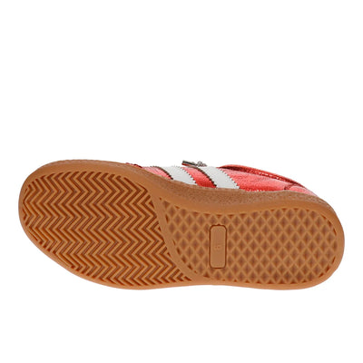 A single shoe shown from the sole view, featuring a textured brown rubber outsole and a red and white upper.