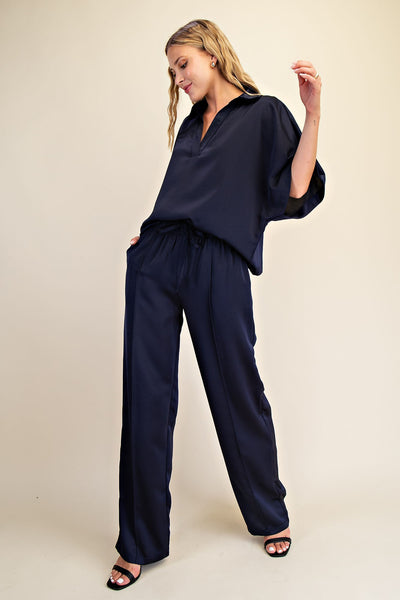 Woman wearing a navy blue outfit on a beige background