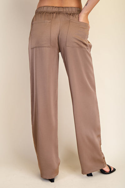 Brown pants worn by a person on a plain background