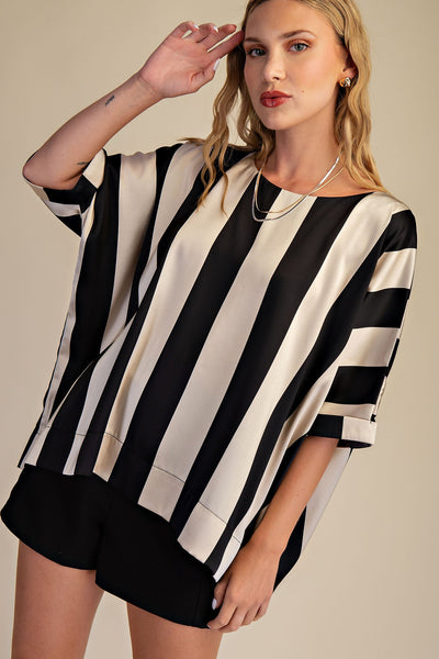 Woman wearing a black and white striped shirt with a beige background