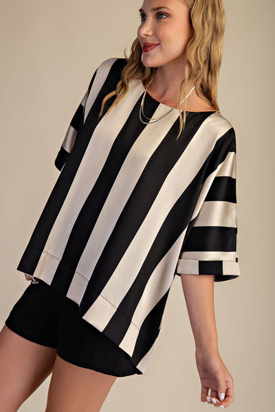 Woman wearing a black and white striped shirt with a plain background