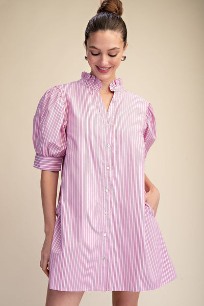 Woman wearing a pink and white striped dress against a beige background