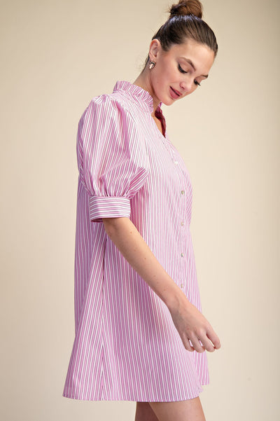 Woman wearing a pink and white striped dress against a beige background