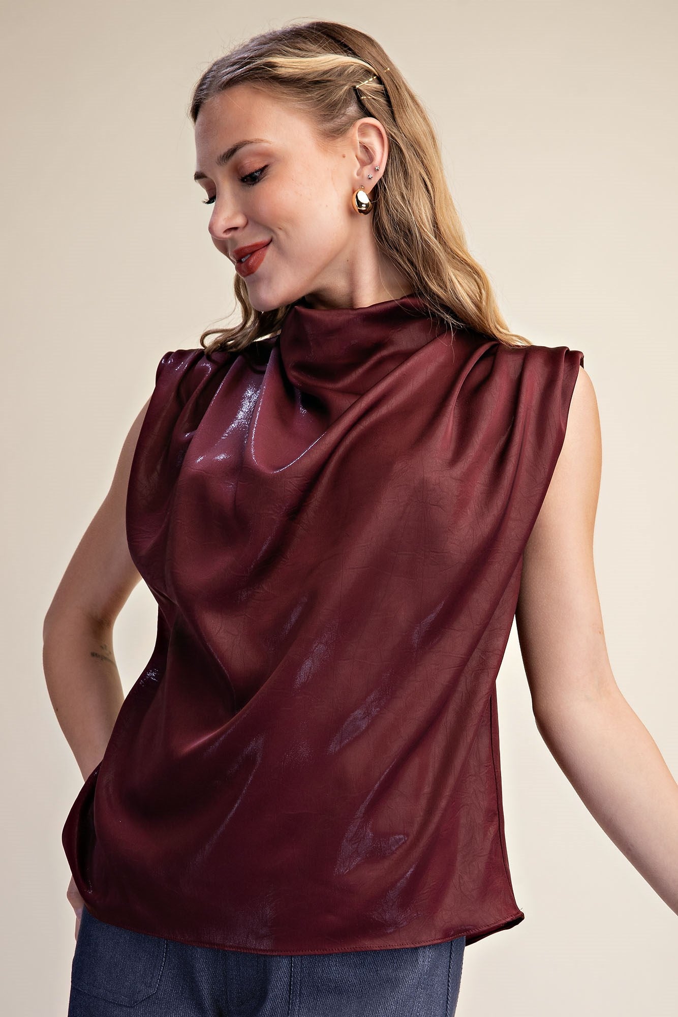 model wearing sleeveless shimmer burgundy top & jeans