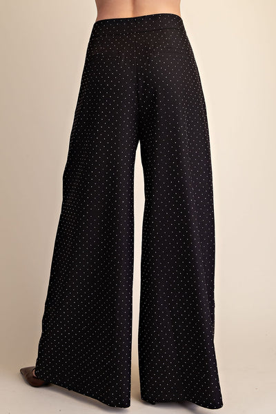 Black wide-leg pants with rhinestones, shown from the back on a model against a light beige background.