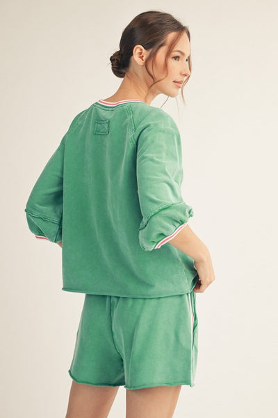 model wearing a green top & shorts