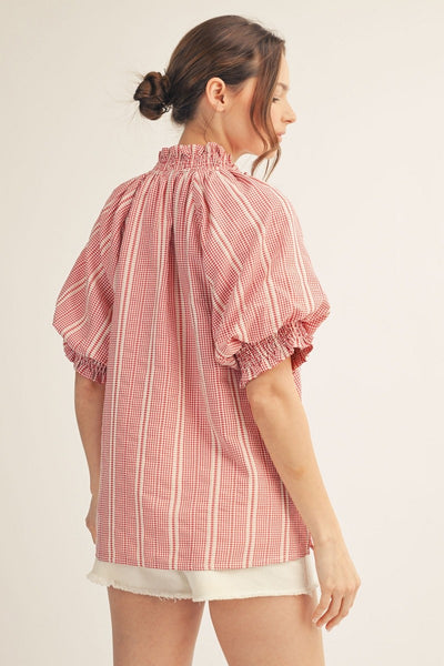 model wearing a red striped top & white shorts