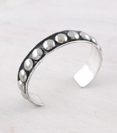 A silver cuff bracelet displayed against a white background.