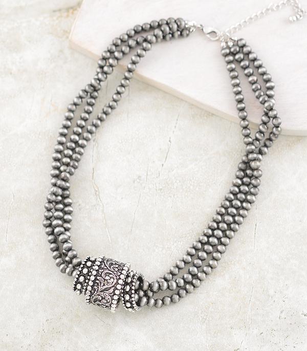 triple strand necklace with silver rings on a light background