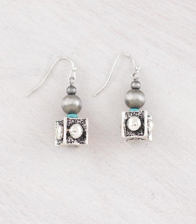 Pair of earrings with gray beads and square silver charms on a light gray background
