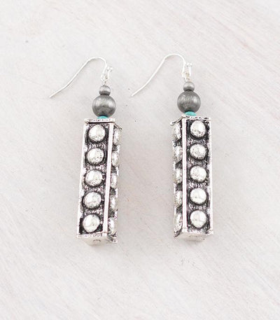 Pair of earrings with block silver beads and gray beads on a light gray background