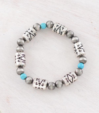 Bracelet with silver beads and silver patterned accents on a light wooden surface