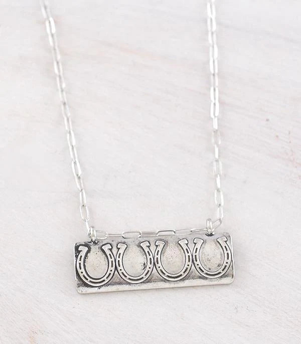 silver horseshoe bar necklace on white background