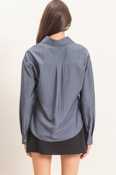 back of model wearing blue striped top and black skirt on a light background