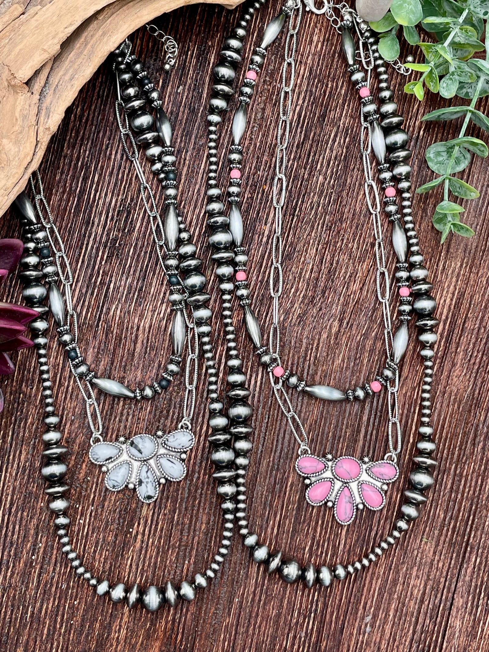 Set of beaded necklaces with stone pendants on a wooden surface
