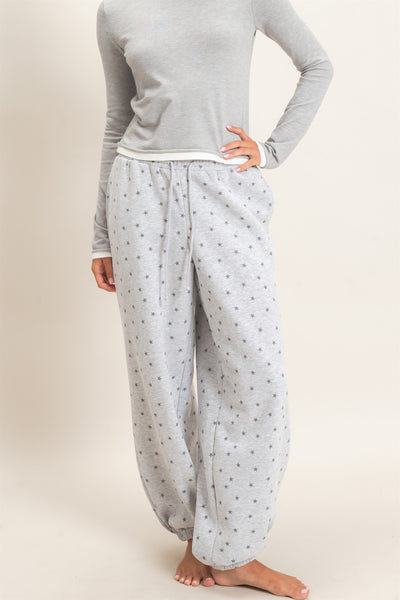 model wearing a gray top and gray joggers with stars