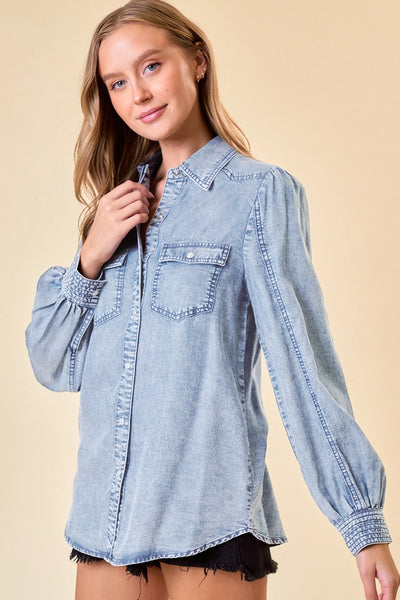 model wearing a long sleeve denim top & cutoff shorts on tan background