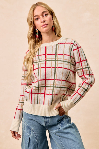 Woman wearing a plaid sweater and jeans against a beige background