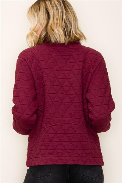 Maroon quilted jacket worn by a person on a white background