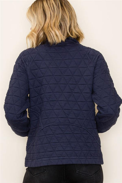 Navy quilted jacket worn by a person against a white background