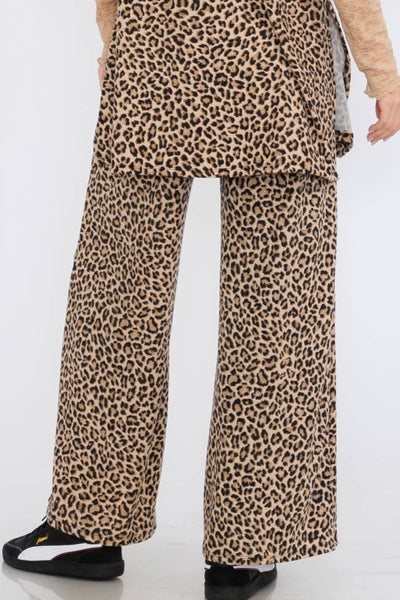 Leopard print pants worn by a person on a white background